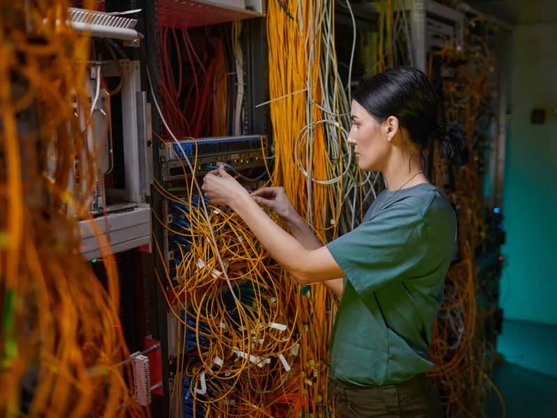woman managing a server to illustrate outsourcing IT benefits